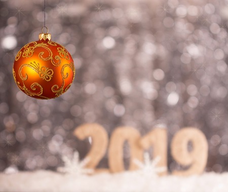Bright yellow Christmas ball and the inscription 2019 new year bokeh backgroundの写真素材