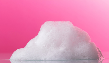 Luxuriant white foam, fragrant handmade soaps on a pink backgroundの写真素材