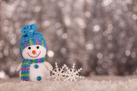 Smiling snowman and snowflakes on a gray background with bokeh effectの写真素材