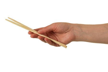 Chinese wooden chopsticks in female hand isolated on white backgroundの写真素材