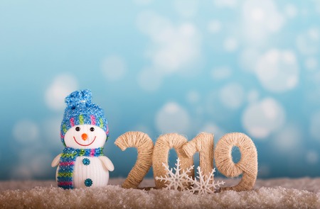Happy smiling snowman and new year inscription 2019 with snow backgroundの写真素材