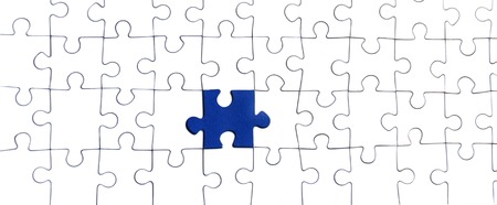 Background of white puzzle with a bright blue puzzle centerの写真素材
