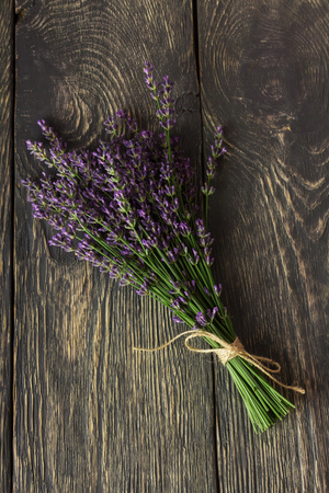 Fresh, fragrant bouquet of lavender on a background of dark boardsの写真素材