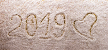 Bright beautiful lettering 2019 new year and a big heart a snow backgroundの写真素材
