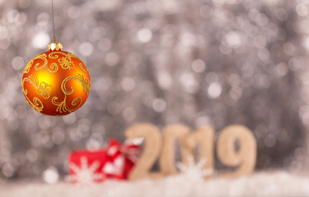 New year inscription 2019 with a snow background and bright yellow christmas ballの写真素材