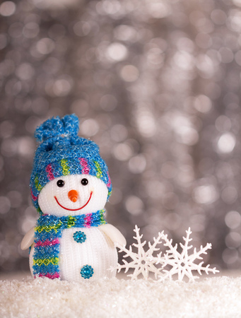 Smiling snowman and snowflakes on a gray background with bokeh effectの写真素材
