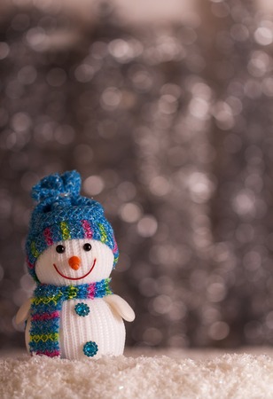 Smiling snowman and snowflakes on a gray background with bokeh effectの写真素材