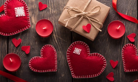 Gifts and bright red hearts for Valentine's day on wooden background