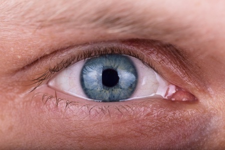 Attentive penetrating male beautiful blue gaze. The man's eyes closeupの写真素材