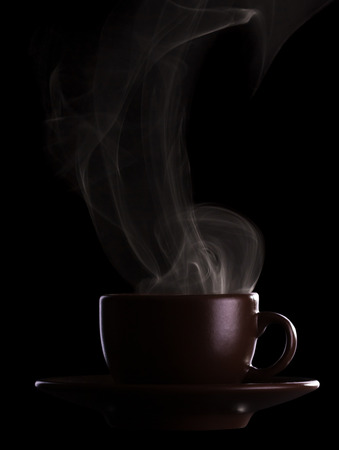 Silhouette coffee cups with saucer and hot steam isolated on black backgroundの写真素材