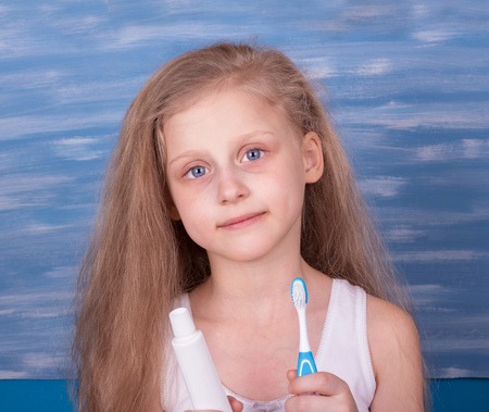Little blonde girl is going to brush your teeth in the bathroomの写真素材