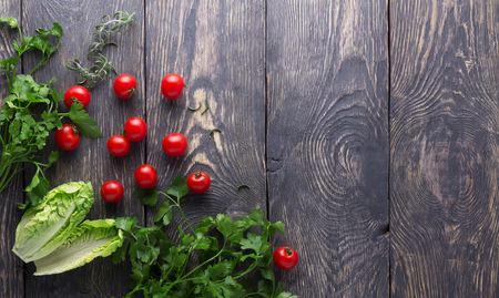 Small cherry tomato and fresh parsley on a wooden boardsの写真素材