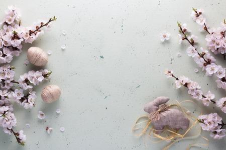 Top view. Easter Bunny is handmade from burlap, decorative balls of twine and flowers on a light backgroundの写真素材