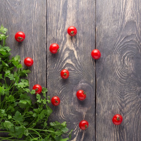 Top view. Fresh tomatoes and parsley on a wooden boardsの写真素材