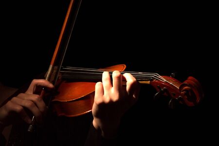 Hands of woman playing violin isolated on black backgroundの写真素材