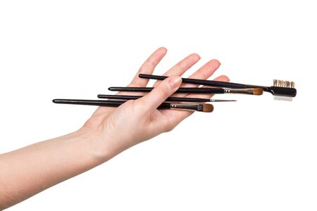 Several different makeup brushes in female hand isolated on white backgroundの写真素材