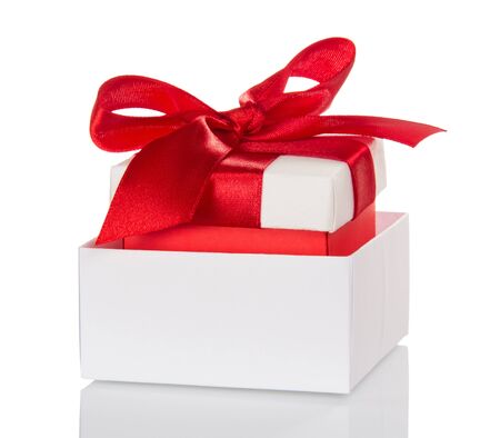 Christmas gifts, decorated with red bow in white box isolated on white backgroundの写真素材