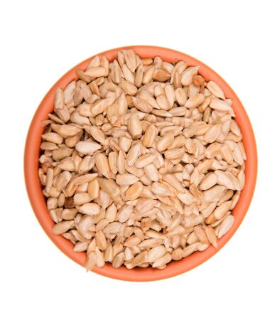 Full bowl of peeled sunflower seeds isolated on white backgroundの写真素材