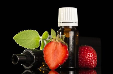 Liquid with fruity scent for smoking an electronic cigarette isolated on black backgroundの写真素材