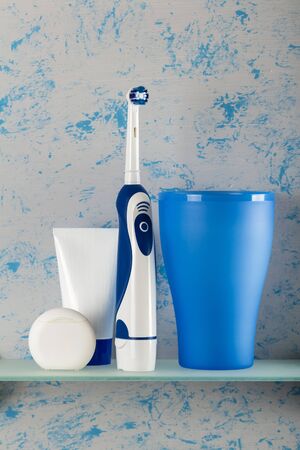 Set for oral care and an electric brush, on glass shelfの写真素材