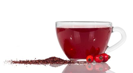 Drink from hips rose, next to crushed dried berries isolated on white backgroundの写真素材