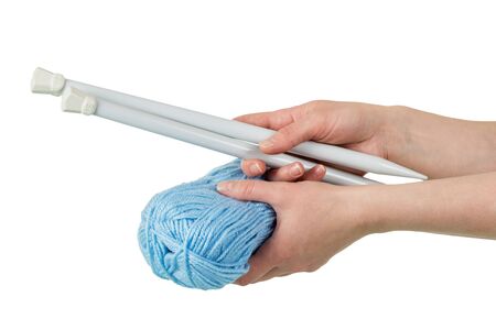 Skein of blue yarn and thick spokes in woman's hands isolated on white backgroundの写真素材