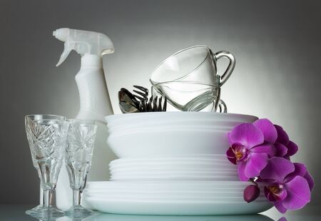 Clean plates and Cutlery, glass cups and crystal glasses, Orchid flower, on grey backgroundの写真素材
