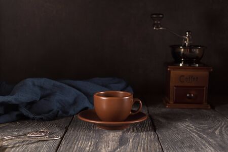 Ceramic Cup and saucer, teaspoons, hand mill for coffee beans, on black backgroundの写真素材