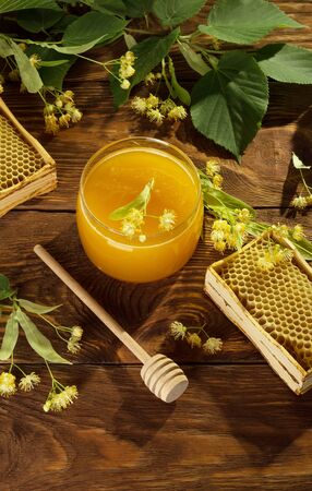 Bee products and wooden honey agitator, on brown surface, top viewの写真素材