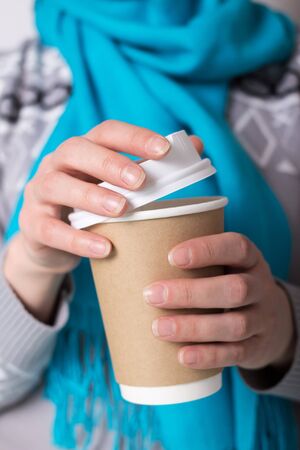 Special container with lid for coffee to take away, in hands of womanの写真素材