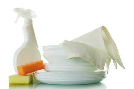 Stack of clean plates and white napkin, detergent, sponge isolated on white backgroundの写真素材