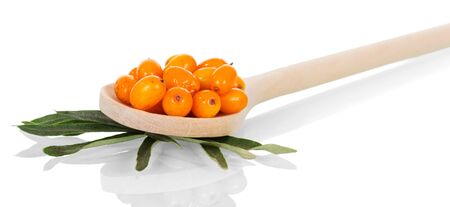Leaves and ripe berries of sea-buckthorn in a wooden spoon close-up isolated on white background.の写真素材