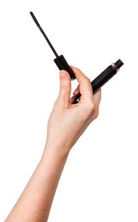 Black mascara and tassel in female hand isolated on white background.の写真素材