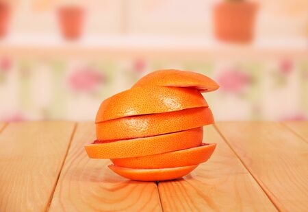 Ripe grapefruit, cut into circles, folded as one closeup on the background of the kitchen.の写真素材