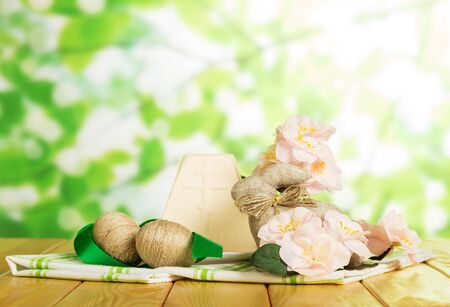 Traditional Easter cheese dessert, Easter Bunny, eggs entwined with string, cloth, flowers and ribbon on abstract green background.の写真素材