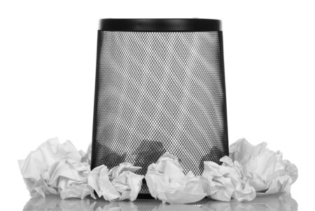 Black empty basket for paper waste bottom up and around balls of crumpled paper isolated on white background.の写真素材