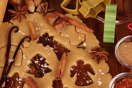 Dough, formed biscuits, spices, molds on a wooden tableの写真素材