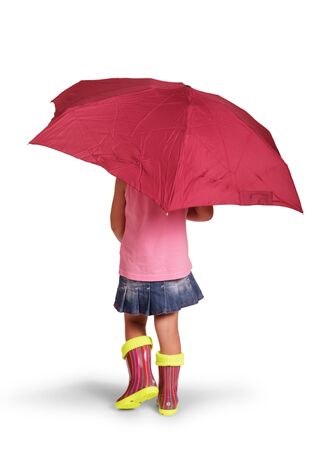 Little girl under an umbrella in rubber boots, isolated on white backgroundの写真素材