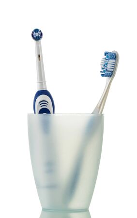 Modern electric and manual toothbrush in glass, isolated on white backgroundの写真素材