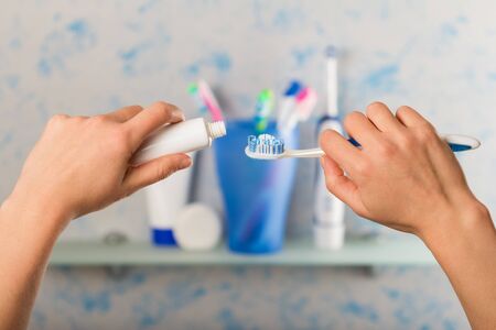 Manual toothbrush and tube of paste in female hands, close-upの写真素材