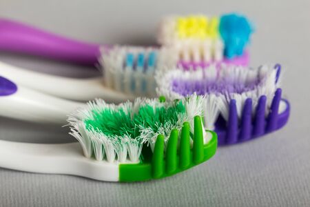 Manual toothbrushes of different degree of rigidity, close-up, on gray backgroundの写真素材