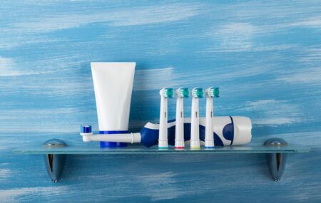 Electric brush and replaceable nozzles for the whole family and toothpaste, on glass shelfの写真素材