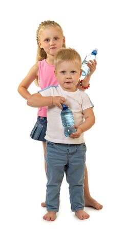 Barefoot boy and girl are standing side by side, holding water bottle isolated on white backgroundの写真素材
