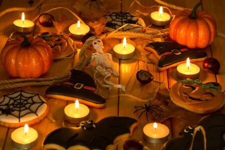 Composition for Halloween in the light of candles. Gingerbread, spiders, skeleton, pumpkinsの写真素材