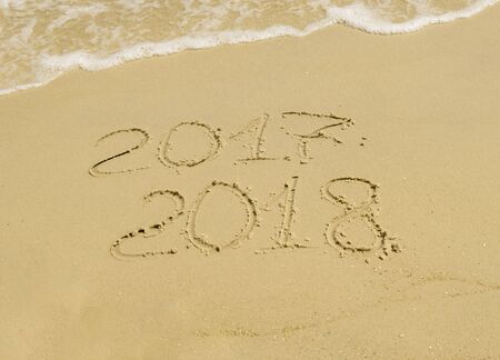 An inscription on sand with sea foam 2017 2018, a holiday on a warm coastの写真素材