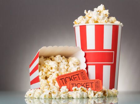 Movie tickets spilled popcorn and two boxes on a gray backgroundの写真素材
