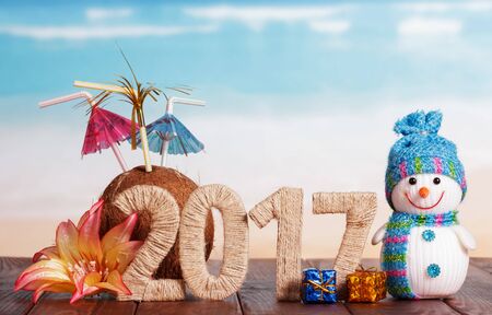 2017 Inscription on the boards, snowman and a Christmas tinsel on a background of the seaの写真素材