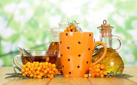 Sea Buckthorn tea, butter and berries on a green backgroundの写真素材