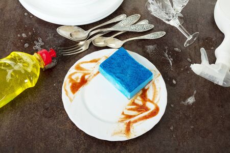 Dirty dishes, detergent and sponge isolated on black backgroundの写真素材