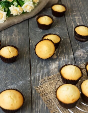 Appetizing freshly baked cupcakes in molds, on gray wooden surfaceの写真素材